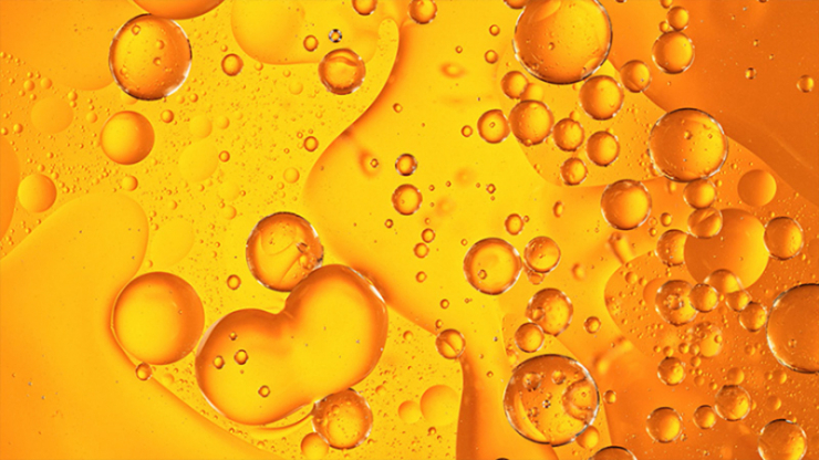 orange liquid with bubbles floating inside