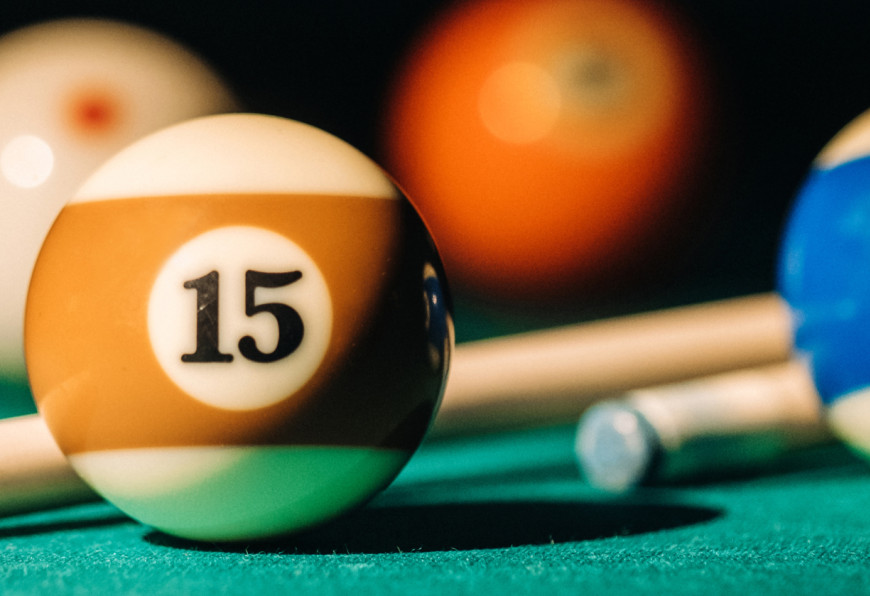 Billard balls and cues on a green felt surface